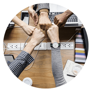 A group of people holding hands in front of a laptop.