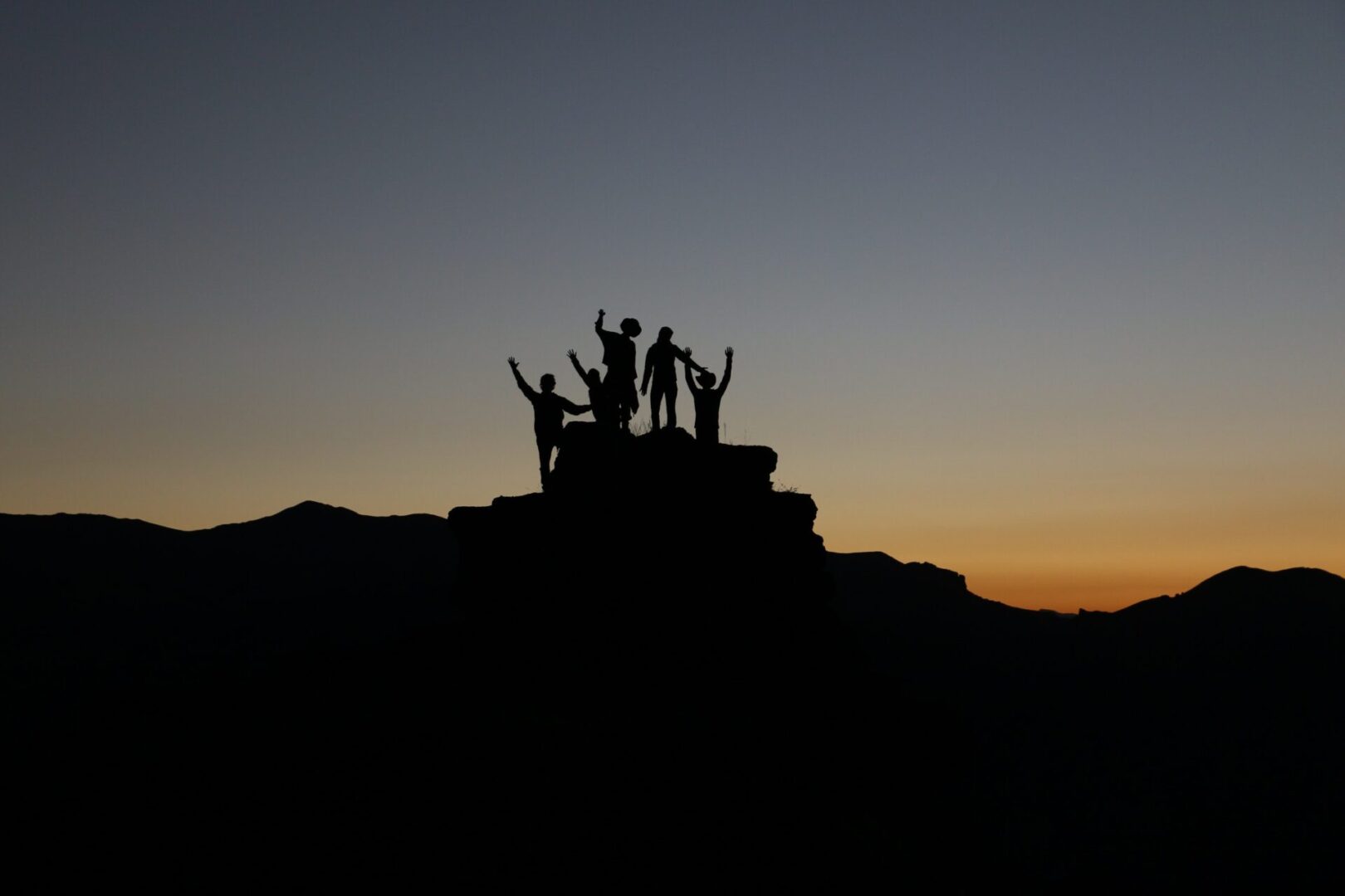 A group of people standing on top of a hill.